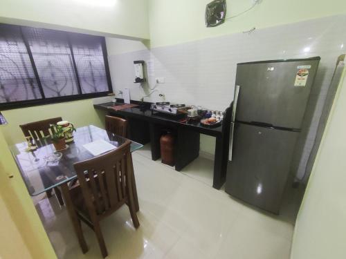 帕纳吉Serene Homestay的厨房配有不锈钢冰箱和桌子
