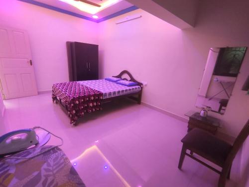 帕纳吉Serene Homestay的卧室配有一张床铺,位于带粉红色灯的房间