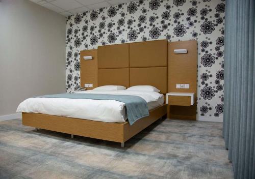 苏莱曼尼亚Rawaz Hotel & Motel的一间卧室配有一张大床和大床头板
