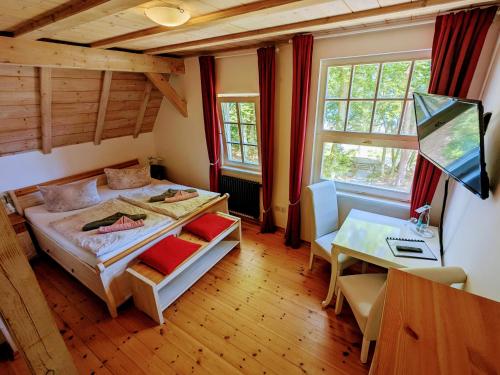 奥斯赛拜-塞林Strandhotel Lindequist的一间卧室配有一张床、一张书桌和窗户。