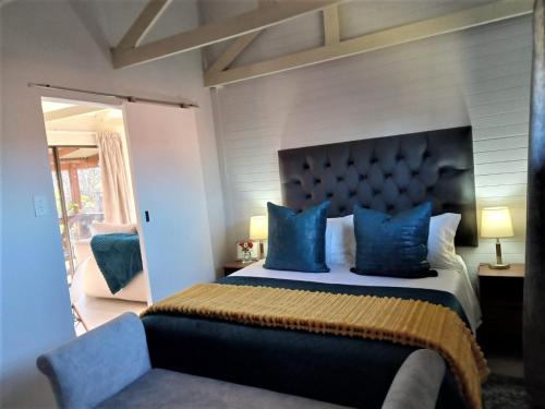 德尔斯特鲁姆Cinnamon & Sage Country Cabins的一间卧室配有一张特大号床和蓝色枕头