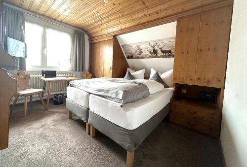 欣特察尔滕Hotel Zartenbach B&B的一间卧室配有一张床、一张书桌和一个窗户。