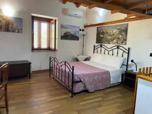 杰拉切La Casetta的一间卧室配有一张床、一张桌子和一个窗户。
