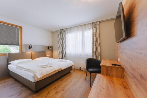 阿诺尔德施泰因Die Pension Galle的一间卧室配有一张床、一张书桌和一台电视