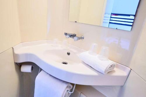 茹埃莱图尔南图尔 - 图尔若普瑞米尔经典酒店的浴室设有白色水槽和镜子