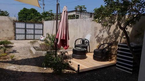 圣多美Hostel Sao Gabriel的一个带遮阳伞、一些锅和围栏的庭院