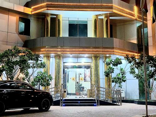 沙鲁拉Address Sharurah Hotel的停在大楼前的一辆黑色汽车