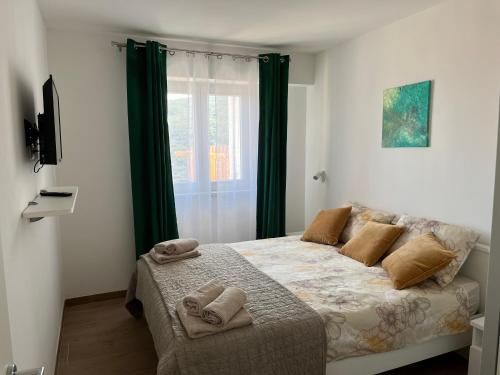 拉巴克Apartments Zahtila - Berto的一间卧室配有一张床,上面有两条毛巾