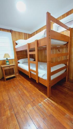 纳塔列斯港Hotel y Cabañas Llanuras de Diana - Caja Los Andes的铺有木地板的客房内配有两张双层床。