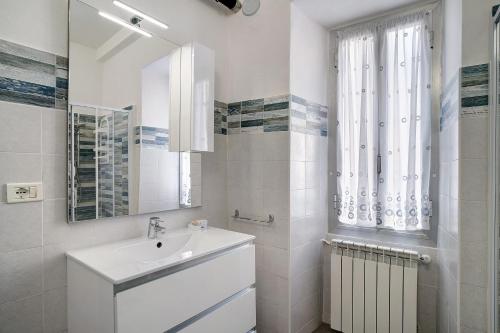 因佩里亚Casa Acqua Mare Parasio的白色的浴室设有水槽和镜子