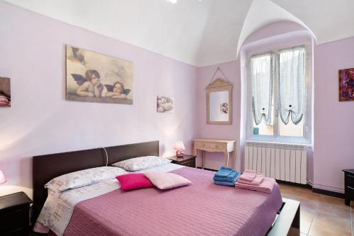 因佩里亚Casa Acqua Mare Parasio的一间卧室配有一张带粉色和紫色床单的床
