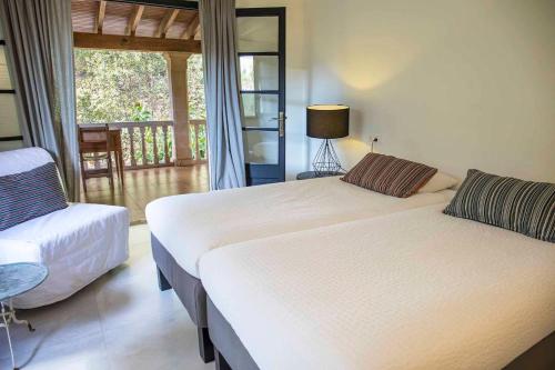 马略卡岛帕尔马Villa Margarita的一间带两张床和椅子的卧室以及一个阳台