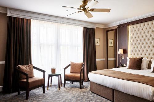 泰晤士河畔金斯顿Warren House Hotel的酒店客房设有床和窗户。