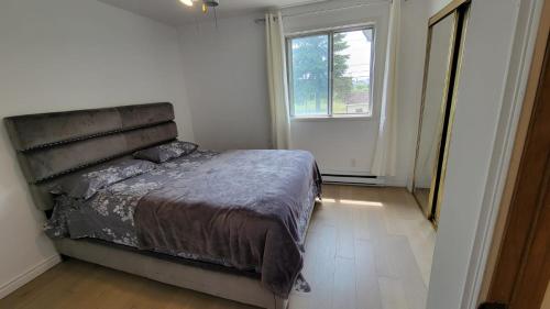 拉瓦尔Vacation House central location from anywhere in Montreal的一间卧室设有一张大床和一个窗户。