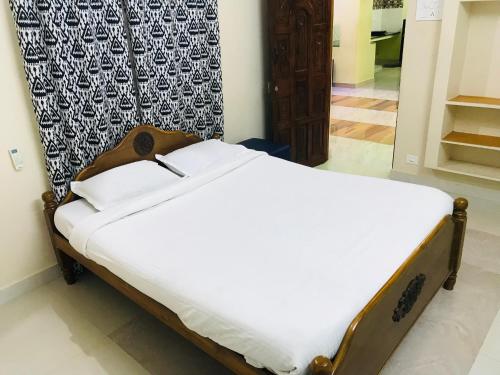 蓬蒂切里ECO VILLA的一张位于带白色床单的房间的床铺