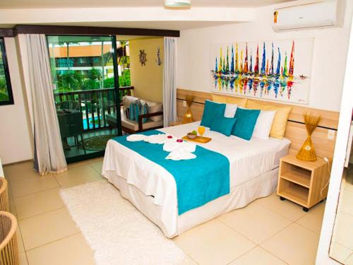 嘎林海斯港Porto Beach Resort - Marulhos的一间卧室配有一张带蓝白色床单的大床