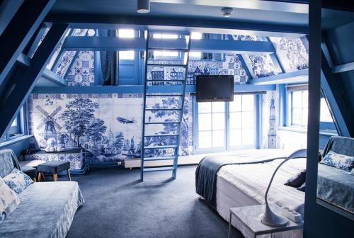 阿姆斯特丹T酒店的一间带蓝色墙壁、一张床和电视的卧室