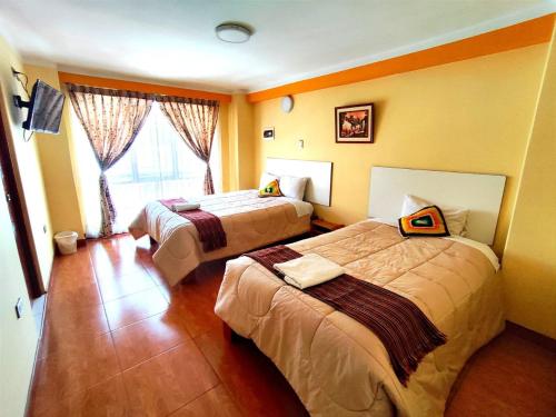 普诺SUMAQ PUNO的酒店客房设有两张床和窗户。