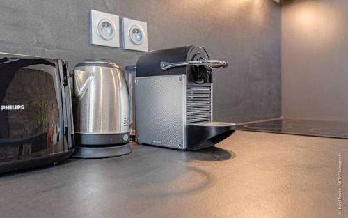 里摩日Les suites locarno的厨房柜台配有咖啡机和烤面包机