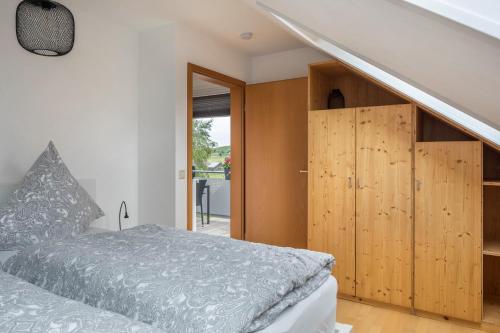 布莱特瑙Weitblick的一间卧室配有一张床和木制橱柜