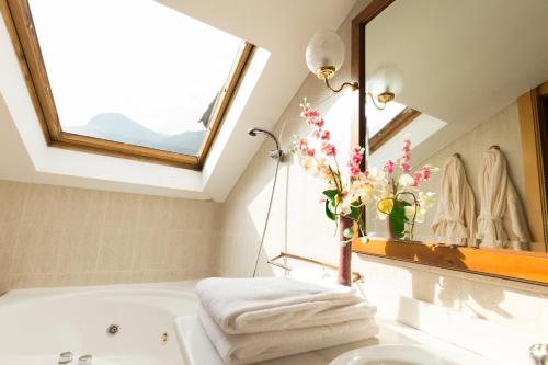 恩坎普巴黎酒店的一间带水槽和浴缸的浴室,并设有一个窗口