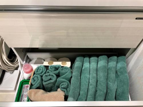 那霸コンドミニアムHARU 那覇県庁前 202的冰箱里装有绿色毛巾的抽屉