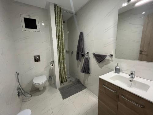 马拉喀什ASAMA appartement avec piscine的白色的浴室设有卫生间和水槽。