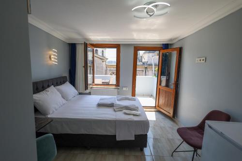 伊斯坦布尔Merdin Suites & Hotel - Downtown的一间卧室设有一张大床和一个窗户。