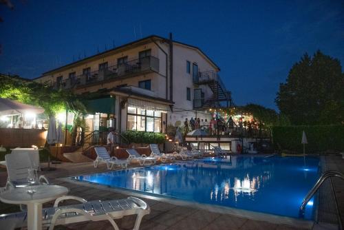 帕拉蒂科Hotel Stazione sul lago di Iseo的夜间在酒店前的游泳池