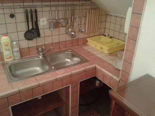 尼库加姆Apartments Belvedere - A2的厨房配有水槽和瓷砖台面