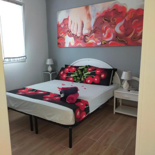 圣伊西多罗B&B Al Melograno的卧室内的一张床铺,墙上有绘画作品