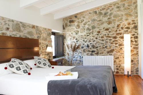 莫奈斯MONELLS - CASA Rural - CAN FELIP的一间卧室设有一张床和石墙
