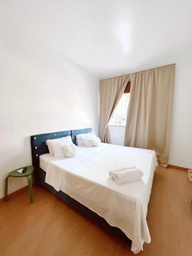 里斯本Residencial First One的一间卧室配有一张带白色床单的床和一扇窗户。