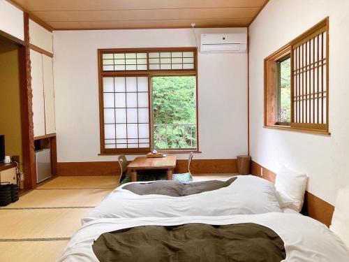 箱根YUPOPPO Hakone的一间带一张大床的卧室,位于带窗户的房间内