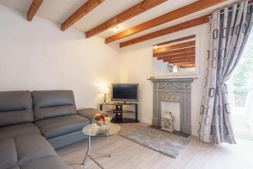 桑希尔Dalgarnock Cottage的带沙发和壁炉的客厅