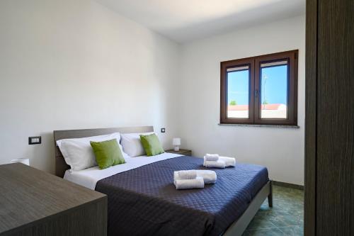 洛特佐拉伊5 - Relax e comfort in casa con giardino - Sa Crai Apartments Sardinian Experience的一间卧室配有带毛巾的床