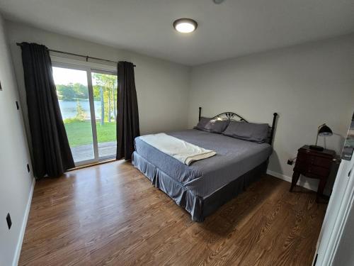 圣约翰Douglas Lake Paradise AB的一间卧室设有一张床和一个大窗户