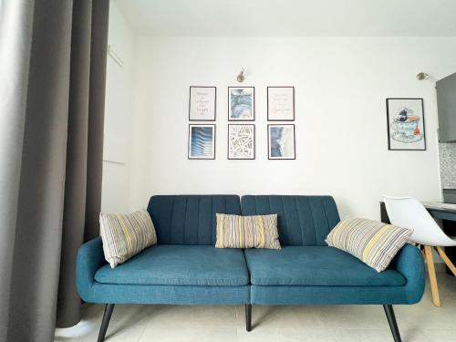 托里格兰德Sunnyside Apartment的客厅里一张蓝色的沙发,配有窗帘