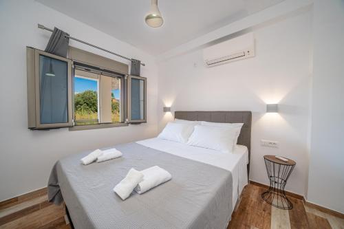 萨米Mirabilia Apartment的一间卧室配有一张带两条白色毛巾的床