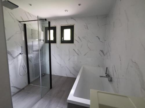 多勒La Rive du Doubs - 2 chambres - 5 Pers - 56, Chemin du Canal Du Rhône au Rhin的白色的浴室设有浴缸和水槽。
