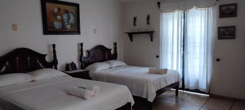 卡特马科Posada Bugambilias的一间卧室配有两张带毛巾的床