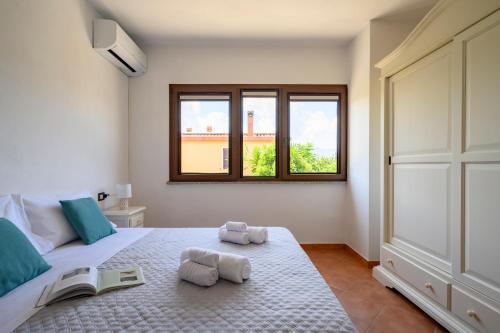 洛特佐拉伊6 - Meraviglioso appartamento con terrazza - Sa Crai Apartments Sardinian Experience的一间卧室配有一张床,上面有两条毛巾