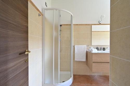 洛特佐拉伊6 - Meraviglioso appartamento con terrazza - Sa Crai Apartments Sardinian Experience的浴室里设有玻璃门淋浴