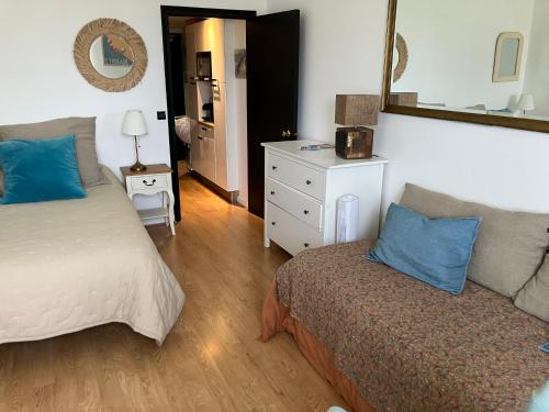 比亚里茨Studio phare de Biarritz Résidence Régina Golf的一间卧室配有一张床、一张沙发和一面镜子
