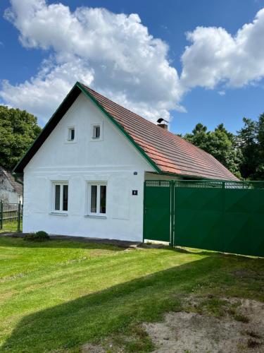 Chalupa Františkov的白色的房子,有红色的屋顶和绿色的围栏