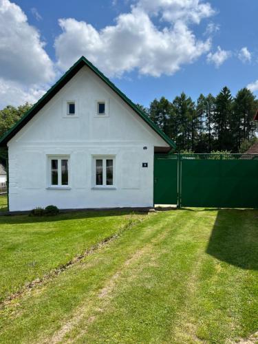 Chalupa Františkov的院子中带绿色围栏的白色房子