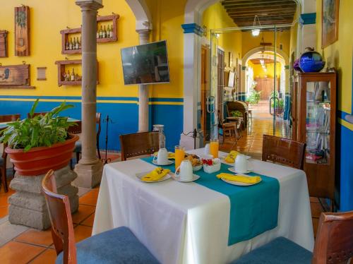 Sayula拉卡萨德洛斯天井及温泉酒店的餐厅的一张桌子,墙上是蓝色和黄色的