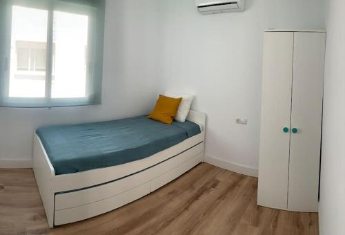 阿尔么丽亚ATICO PASEO DE ALMERÍA的一间卧室配有一张黄色枕头的床