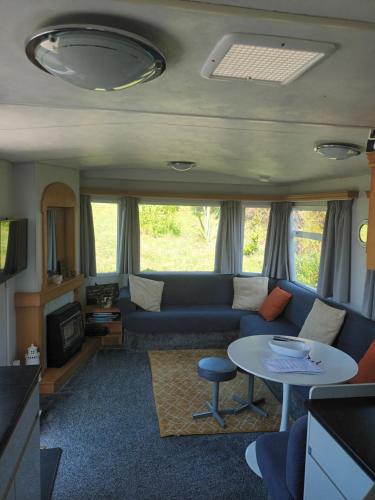 彭赞斯Carn Kenidjack View Caravan, space, peace and tranquillity的客厅配有沙发和桌子