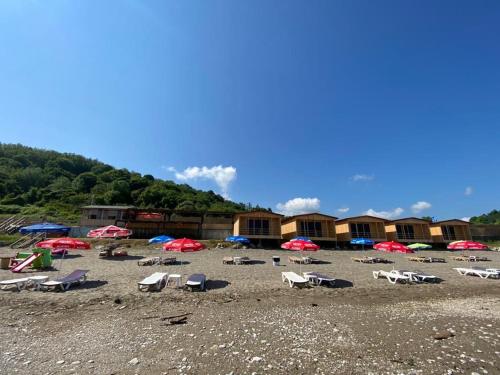 阿克恰科贾Black Sea Beach Bungalow的海滩上的一组椅子和遮阳伞
